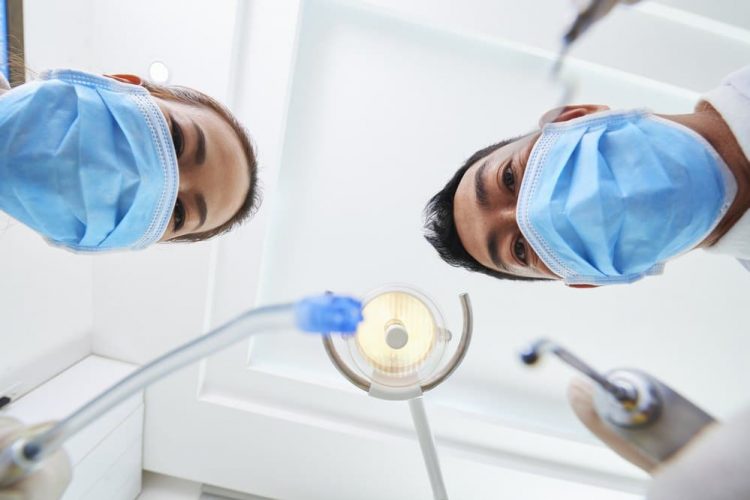 dentists standing over a patient