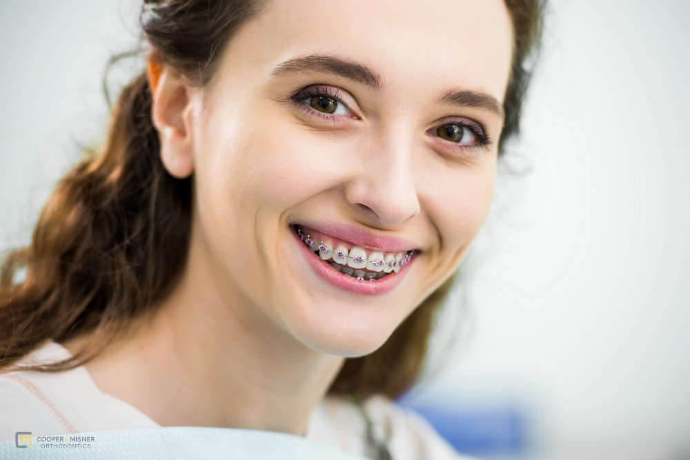 a woman with metal braces smiling at the camera after understanding how long do braces take in tulsa, ok