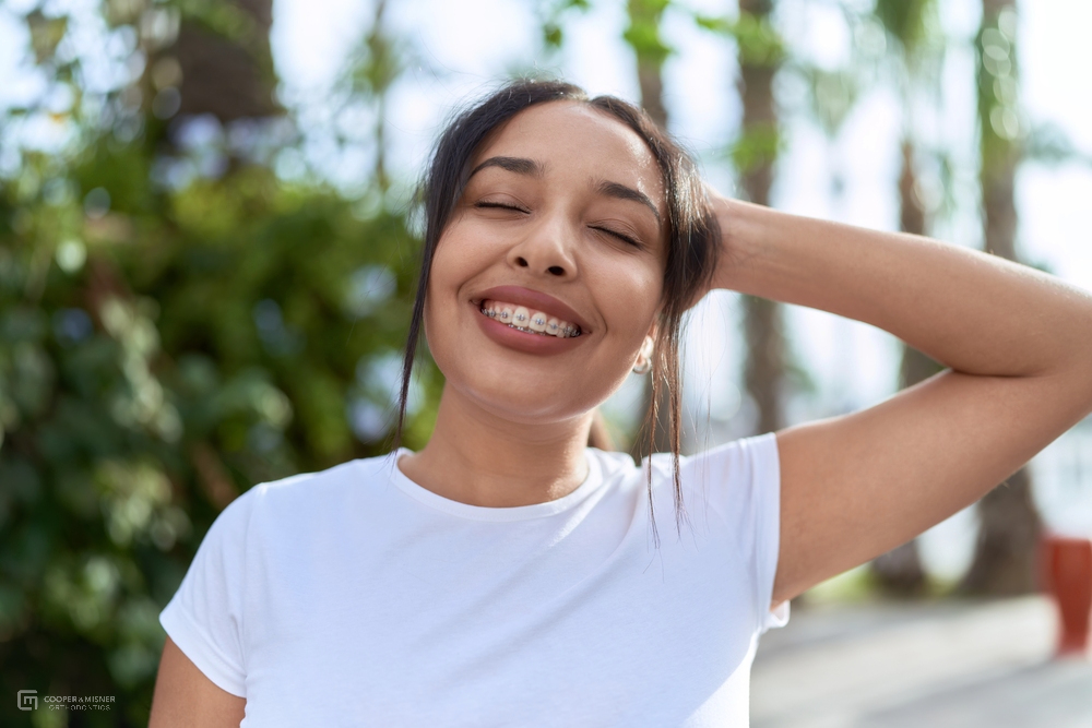 a woman smiling showing her metal braces as her choice after considering aligners vs braces in tulsa, ok
