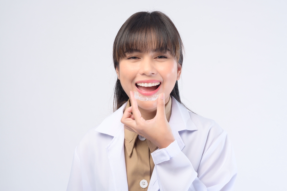 young female dentist holding invisalign clear aligners - Can Invisalign Fix Overbite in Tulsa, OK
