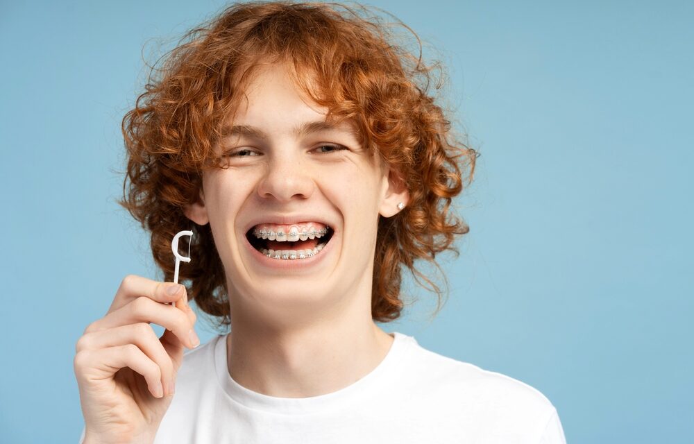 close up image smiling teenager curly red hair metal braces - How to Floss with Braces in Tulsa, OK
