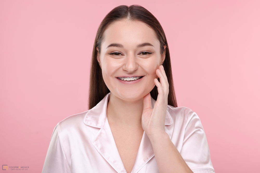 smiling woman dental metal braces pink - How to Get Braces Glue Off Teeth in Tulsa, OK