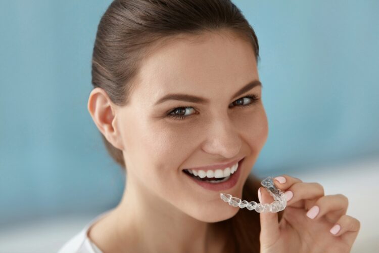 dental care smiling woman using invisalign clear aligners - How Does Invisalign Work in Tulsa, OK