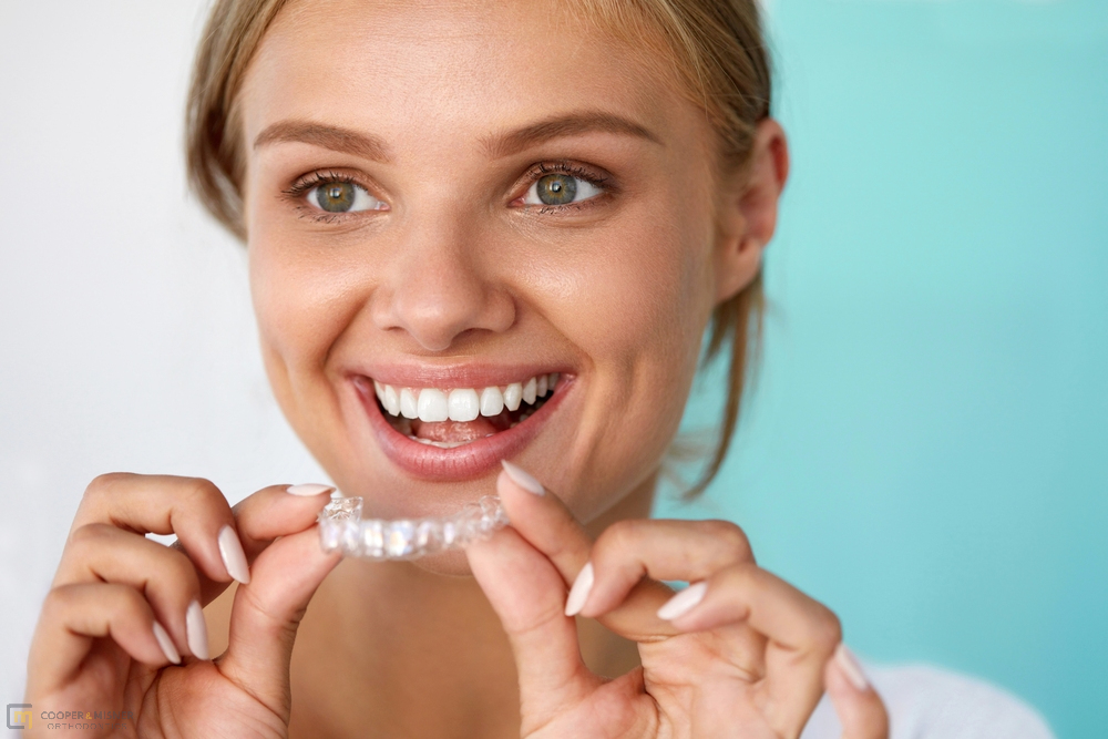 smiling woman with beautiful smile using invisalign clear aligners - How Does Invisalign Work in Tulsa, OK 